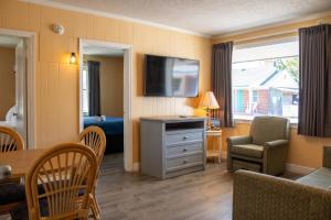 a living room with a television and a dining room at Colonial Inn in Nags Head