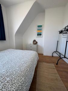 a white bedroom with a bed and a ladder at Le logis de la Marina in Calais
