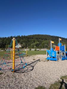 a playground with a swing set in a field at Pokoje Gościnne Nad Zalewem w Starej Morawie in Stronie Śląskie