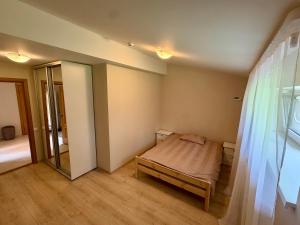 a small bedroom with a bed and a mirror at Männimetsa in Narva-Jõesuu