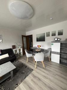 a living room with a couch and a table and chairs at Ferienwohnung Waldblick in Winterberg