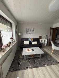 a living room with a couch and a table at Ferienwohnung Waldblick in Winterberg