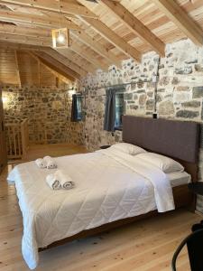 a bedroom with a large bed in a stone wall at Mesovouni Stone Suites 1 in Mesovounion-Zagori