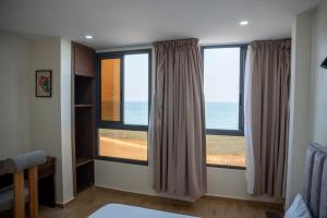 a room with two windows with a view of the ocean at Hola Rio in Dakhla