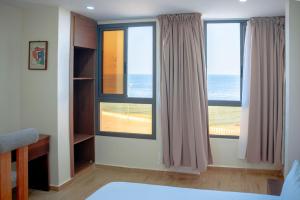a bedroom with windows with a view of the ocean at Hola Rio in Dakhla
