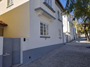 a white building on a cobblestone street at 4-As Andar-Moradia Muralhas in Guimarães