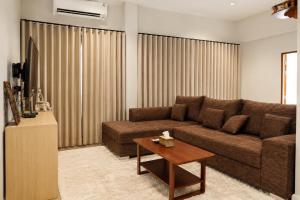 a living room with a brown couch and a table at Sherlock Home Pool Villa Krabi in Ban Chong Phli
