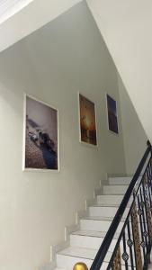 a staircase with three pictures on the wall at Sea Breeze Ras Al Hadd in Sur