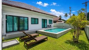 a backyard with a swimming pool and a house at Sherlock Home Pool Villa Krabi in Ban Chong Phli