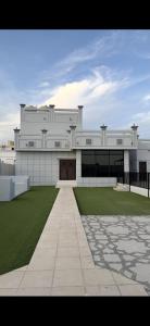 a large white building with a green lawn in front of it at Sea Breeze Ras Al Hadd in Sur