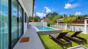 an exterior view of a house with a swimming pool at Sherlock Home Pool Villa Krabi in Ban Chong Phli