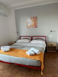 a bedroom with a bed with towels on it at Il Villaggio Hotel Residence Lì Cylentos Elios a 100 mt dal mare cilentomarexperience in Policastro Bussentino +60 photos