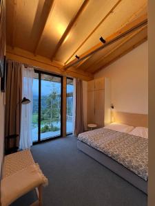 a bedroom with a bed and a large window at Amper Villa Dilijan in Dilijan