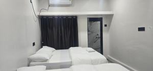 a small room with two beds and a mirror at Tuljapur Bhaktaniwas in Tuljapur +62 photos