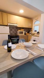 a wooden table with plates and wine glasses on it at Villa Aura, Kanalia Corfu in Corfu