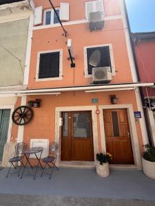 a building with chairs and a table in front of it at Studio apartman Ema in Umag