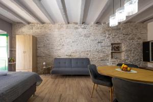 a bedroom with a blue couch and a table at Studio apartman Oreb in Vela Luka