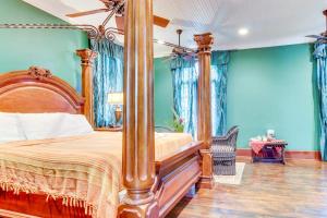 a bedroom with a canopy bed with blue walls at Colonial Suite @ Mahogany Hall in San Ignacio