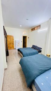 two beds in a room with blue sheets at CLOUD HEIGHTS COTTAGE NATHIA GALi in Nathia Gali +13 photos