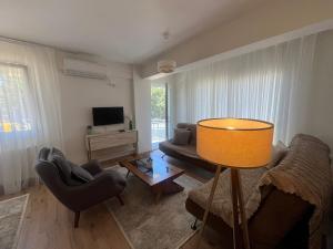 a living room with a couch and chairs and a television at Urla Garden House in Urla