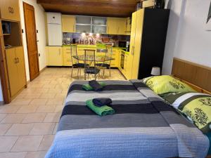 a large bed in a room with a kitchen at Horváth Apartmanház in Szigliget