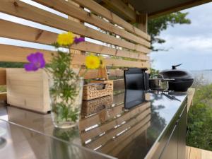 Eine Blumenvase steht auf einer Theke neben einem Tisch. in der Unterkunft Seglinge Glamping in Norrön