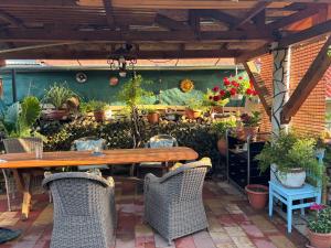 a patio with a wooden table and chairs and potted plants at Horváth Apartmanház in Szigliget