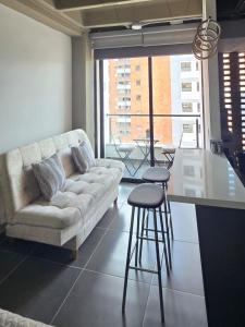 a living room with a couch and a table and stool at apartamento tipo loft en sabaneta in Sabaneta
