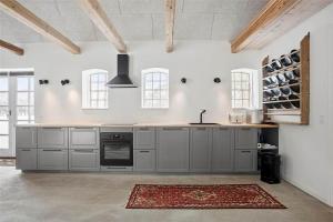 a large kitchen with gray cabinets and a rug at FA028-Karise-Tagerupvej-29 in Karise