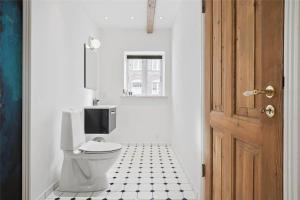 a bathroom with a toilet and a black and white tile floor at FA028-Karise-Tagerupvej-29 in Karise