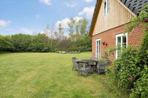 a table and chairs in a yard next to a building at FA028-Karise-Tagerupvej-29 in Karise