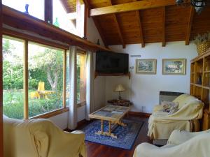 a living room with a tv and a table at Casa Malen Llao Llao in San Carlos de Bariloche