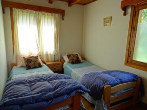 two twin beds in a room with a window at Casa Malen Llao Llao in San Carlos de Bariloche