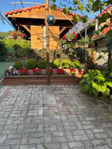 a garden with a woodenilion with flowers and plants at Horváth Apartmanház in Szigliget +6 photos