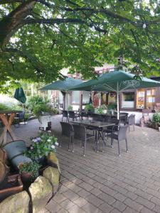 a patio with a table and chairs and umbrellas at Berggasthof Immenstein in Bühl +6 photos