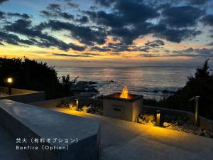a fire pit with a view of the ocean at sunset at THE THIRD PLACE tatéyama 楼 in Tateyama
