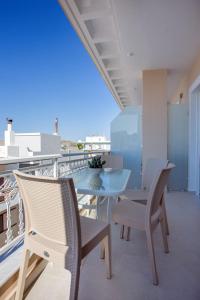 a dining room with a table and chairs on a balcony at Orelia Suite 3 in Karistos