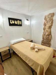 a bedroom with a bed and a stone wall at San Roque 7 in Archidona