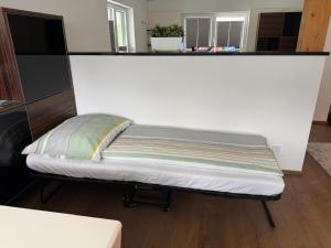 a bed in a room with a white wall at Leos Suite Appartement in Bischofshofen