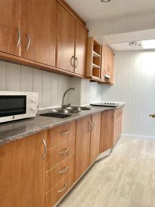 a kitchen with wooden cabinets and a sink and a microwave at San Roque 7 in Archidona +13 photos