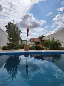 a pool of water with a house and a sky at Séjour Traditionelle in Oulad Teïma