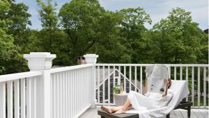 a woman sitting in a chair reading a newspaper on a balcony at The Inn at GrayBarns in Norwalk +31 photos