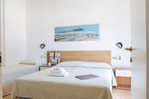a hotel room with two beds and a picture on the wall at Hotel Verbena in Lido di Camaiore