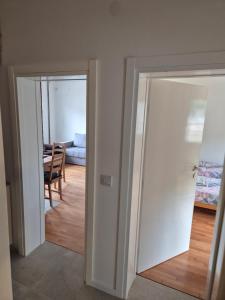 two sliding doors in a room with a table at Drinika in Foča