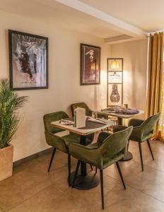 a dining room with green chairs and a table at Hôtel La Villa Cannes in Cannes