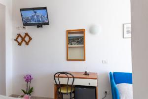 a room with a desk and a tv on the wall at Hotel Verbena in Lido di Camaiore