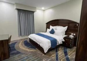 a bedroom with a large bed with a wooden headboard at Elaf Al Sharqyah Hotel -Alaziziah فندق ايلاف الشرقية العزيزية in Al Khobar +22 photos