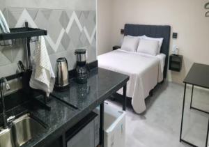 a bedroom with a bed and a kitchen with a sink at Pousada Rainha da Serra in Espirito Santo Do Pinhal
