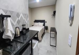 a bedroom with a bed and a kitchen with a counter at Pousada Rainha da Serra in Espirito Santo Do Pinhal