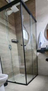a shower with a glass door in a bathroom at Pousada Rainha da Serra in Espirito Santo Do Pinhal